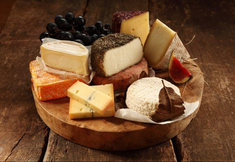 Assorted cheeses on a rustic wooden board