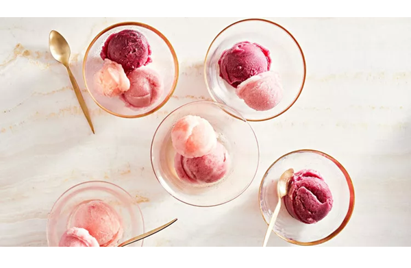 five glass bowls containing scoops of sorbet. Some have two or three scoops of varying shades of pink and purple.